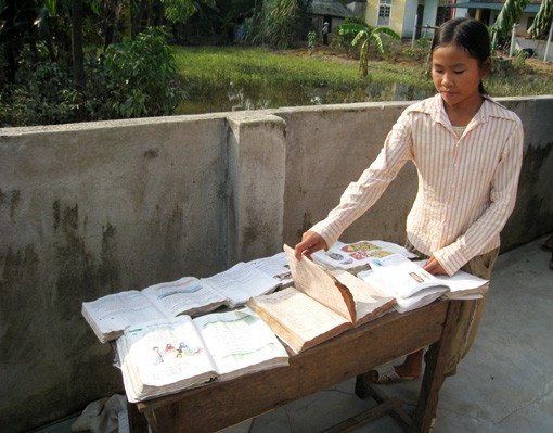 Học sinh vùng lũ tranh thủ trời nắng hong phơi sách vở, đồ dùng học tập