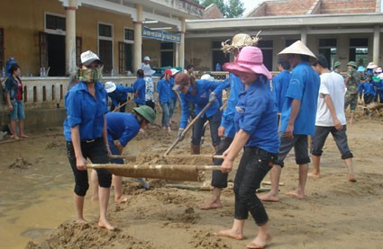 Lực lượng thanh niên tình nguyện tham gia nạo vét bùn đất sau lũ tại Trường mầm non xã Đức Giang