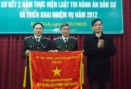 Phó Chủ tịch Thường trực UBND tỉnh Trần Minh Kỳ trao tặng Cờ thi đua xuất sắc của UBND tỉnh cho Chi cục THA DS huyện Đức Thọ
