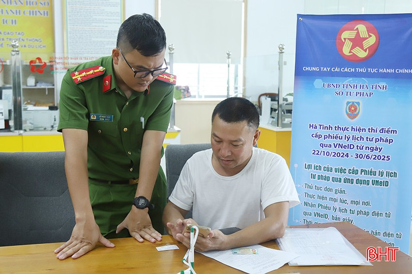 Cán bộ Phòng Cảnh sát QLHC về TTXH (Công an tỉnh) trao đổi với người dân về các thao tác trên ứng dụng VNeID. bqbht_br_h.jpg