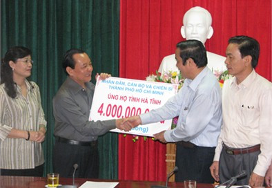 Bí thư Thành uỷ Tp HCM Lê Thanh Hải (thứ hai từ trái sang) trao tặng biển tượng trưng 4 tỷ đồng ủng hộ lũ lụt cho ông Nguyễn Thanh Bình Bí thư Tỉnh uỷ Hà Tĩnh