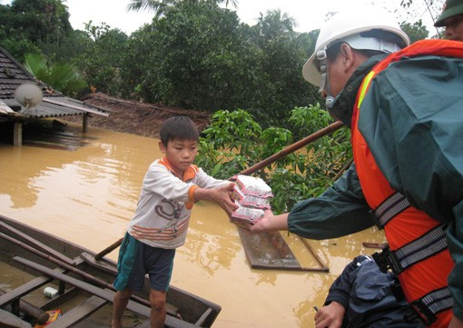 Phó Chủ tịch UBND tỉnh Lê Đình Sơn phát mỳ tôm và nước uống cho bà con giáo dân Giáo xứ Đông Hải (Gia Phố) đang đến tránh lũ tại nhà thờ Người dân xóm 14, xã Gia Phố phải dỡ ngói để vào nhà