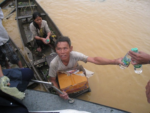 Phó Chủ tịch UBND tỉnh Lê Đình Sơn phát mỳ tôm và nước uống cho bà con giáo dân Giáo xứ Đông Hải (Gia Phố) đang đến tránh lũ tại nhà thờ Người dân xóm 14, xã Gia Phố phải dỡ ngói để vào nhà