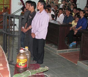 Ba bị cáo Trần Văn Bảo (bìa phải), Trịnh Xuân Toàn (ở giữa) và Trần Văn Tâm, cùng tang vật vụ án