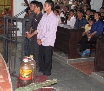 Ba bị cáo Trần Văn Bảo (bìa phải), Trịnh Xuân Toàn (ở giữa) và Trần Văn Tâm, cùng tang vật vụ án