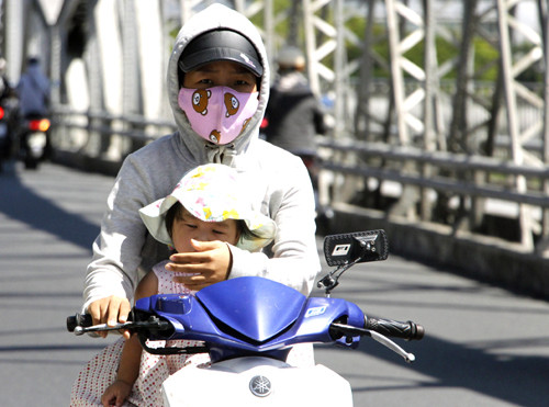 Người phụ nữ chở con gái qua cầu Trường Tiền (Huế) trưa ngày 20/4. Ảnh: Võ Thạnh. Hè 2019, nắng nóng có thể vượt mốc lịch sử một số nơi