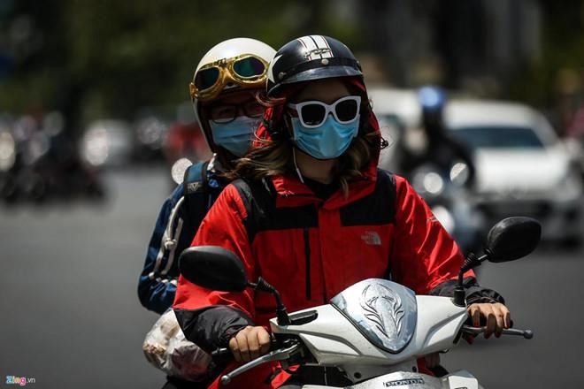 Người dân ra đường luôn phải mặc áo khoác, đeo khẩu trang và kính mát để đối phó với nắng nóng Ảnh: Liêu Lãm Cảnh báo nguy cơ hôn mê khi ra đường từ 12-16h vì nắng nóng