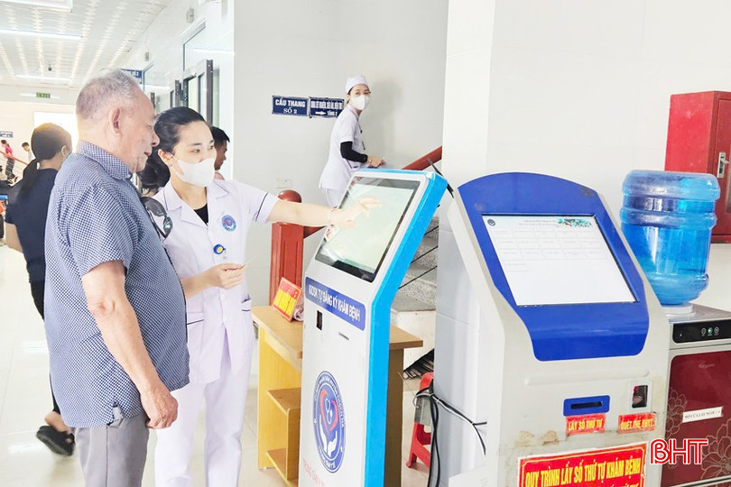 Cán bộ y tế hướng dẫn người dân lấy phiếu khám bệnh tự động. bqbht_br_papi-3a.jpg