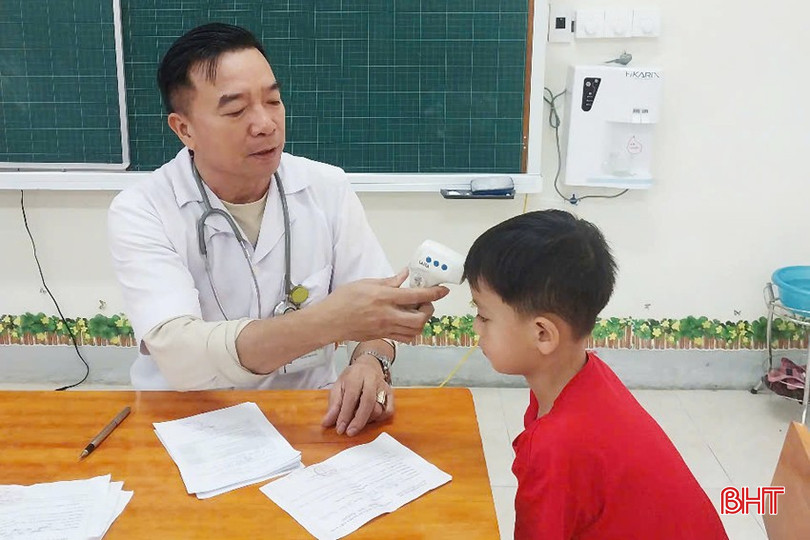 Cán bộ y tế tiến hành khám sàng lọc kỹ lưỡng cho trẻ trước khi tiêm. bqbht_br_1a.jpg