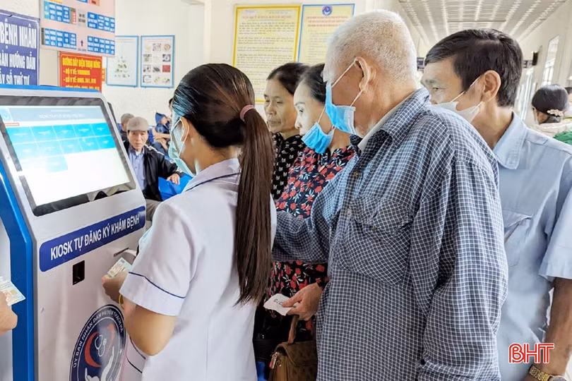 Cán bộ Trung tâm Y tế huyện Thạch Hà hướng dẫn người dân lấy số thứ tự tại ki-ốt đăng ký khám chữa bệnh tự động.