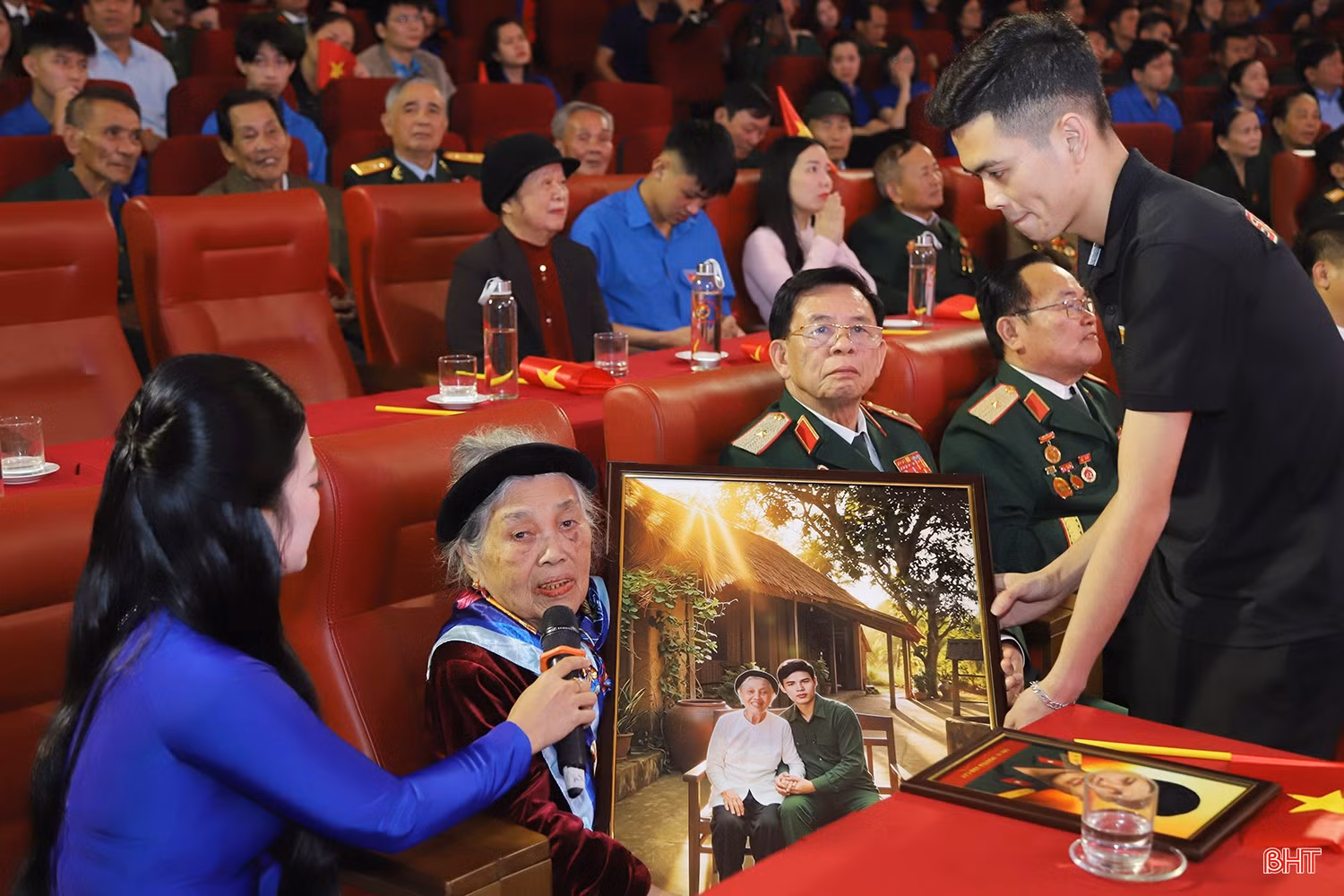 Đại diện nhóm Skyline trao tặng Mẹ Việt Nam anh hùng Trần Thị Huyến bức ảnh phục dựng mẹ và con trai.