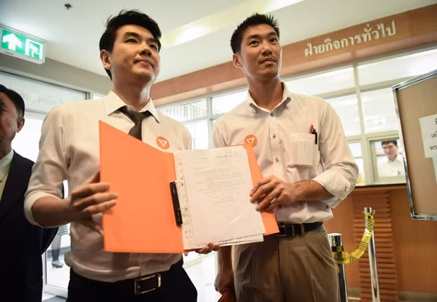 Tỷ phú Thanathorn (phải) và người đồng sáng lập đảng Hướng đến tương lai sau khi đăng ký tên đảng hôm 15/3. Ảnh: AFP. chinh truong thai lan khong co cho cho nguoi tre