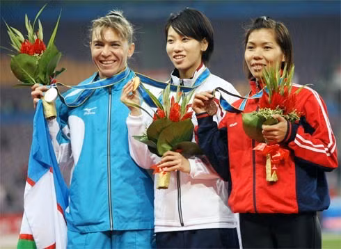 Vũ Thị Hương (phải) khi nhận HC đồng chạy 100 m, sau đó cô còn giành HC bạc chạy 200 m. Ảnh: T.H.