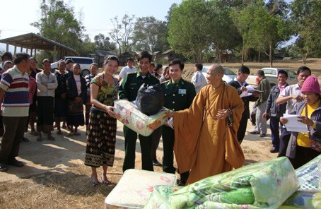 Đại diện nhà tài trợ và Đồn BP Cửa khẩu Cầu treo trao quà hỗ trợ nhân dân các bản ngoại biên (Lào) đối diện với Hà Tĩnh