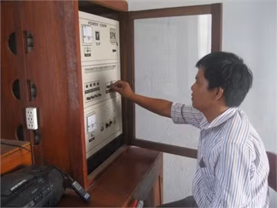 Cán bộ phát thanh đang điều khiển máy phát trong một chương trình tuyên truyền của thị trấn