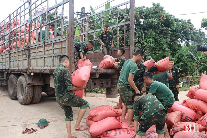 Chiến sỹ Trung đoàn 841 hỗ trợ người dân vận chuyển lúa ngập lụt đi sấy. bqbht_br_4-9348.jpg