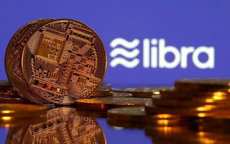 Đồng tiền mô phỏng tiền ảo và logo Libra. Ảnh: Reuters Những biến động của kinh tế thế giới 2019