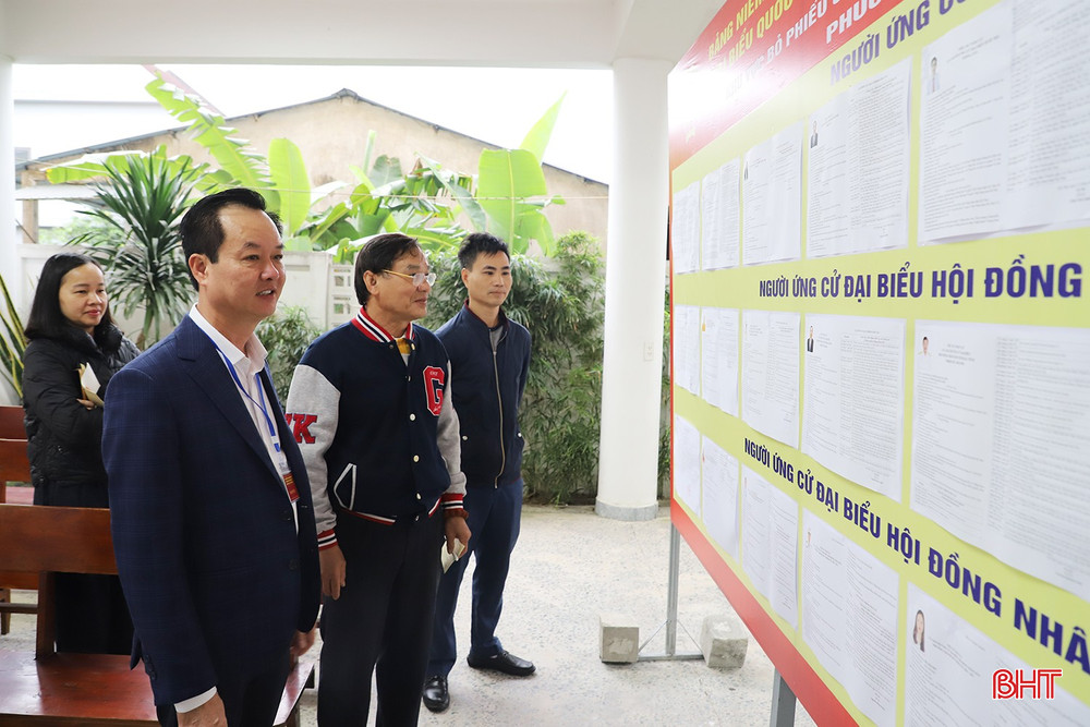 Phó Chủ tịch Thường trực UBND tỉnh Trần Báu Hà và cử tri xem thông tin ứng cử viên.
