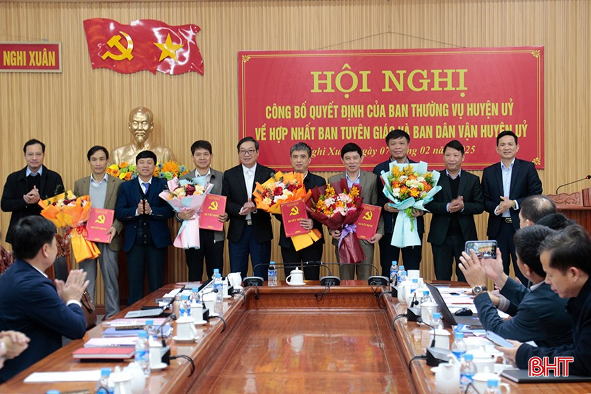 Đại diện lãnh đạo Ban Tổ chức Tỉnh ủy, LĐLĐ tỉnh và huyện Nghi Xuân trao quyết định hợp nhất Ban Tuyên giáo và Ban Dân vận Huyện ủy.