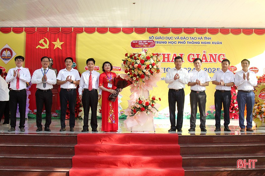 Phó Chủ tịch Thường trực HĐND tỉnh Trần Tú Anh tặng hoa chúc mừng nhà trường.