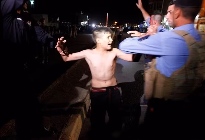 Cậu bé bị cảnh sát bắt tại Kirkuk, Iraq khi đang mang 2 kg bom trên người. Ảnh: Reuters. su tu cua is lan song tre danh bom lan rong