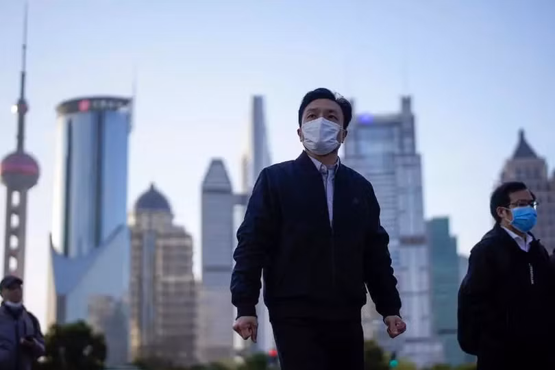 Người dân Trung Quốc đeo khẩu trang tại khu tài chính Lujiazui ở Thượng Hải ngày 19/3. Ảnh: Reuters Châu Á có thể vượt khó vì Covid-19 nhanh hơn phương Tây