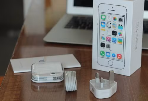 Hộp máy thiết kế theo phong cách iOS 7, hình minh họa phẳng. Bộ phụ kiện đi kèm như với iPhone 5, nhưng thiếu bộ chuyển micro USB sang lightning như ở iPhone 5C.