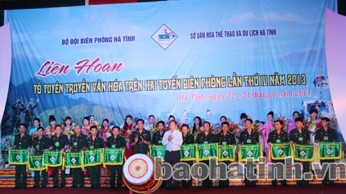 Đại diện lãnh đạo BCH BĐBP tỉnh và Sở VH - TT & DL tặng hoa cho 14 đơn vị tham gia liên hoan