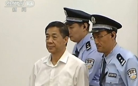 Ông Bạc Hy Lai được hai cảnh sát cao to 'hộ pháp' áp giải ra phiên tòa. Ảnh: CCTV