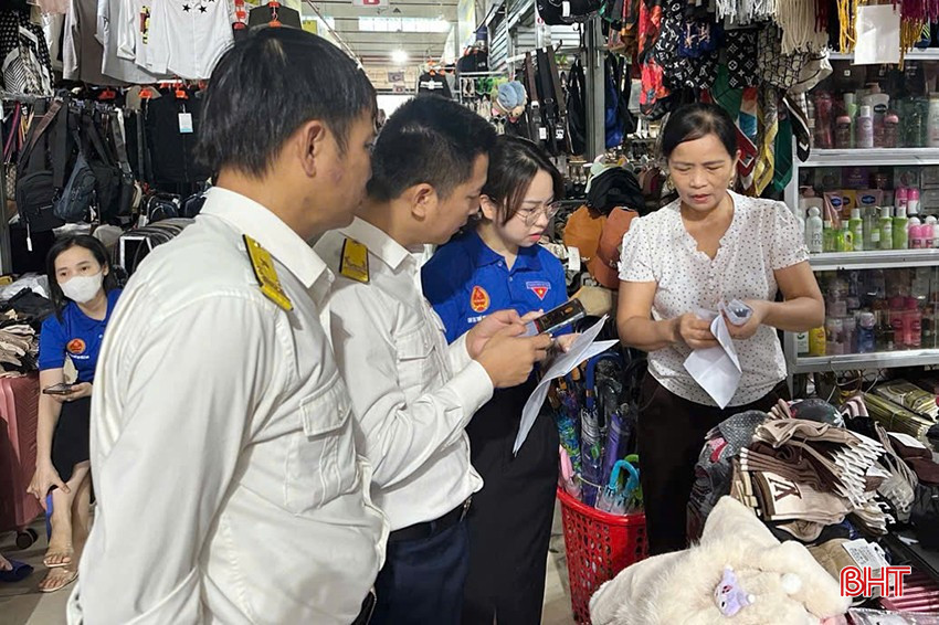 Cán bộ Chi cục Thuế khu vực XI hỗ trợ hộ kinh doanh ở TX Kỳ Anh cài đặt ứng dụng thuế điện tử để kê khai nộp thuế. bqbht_br_4.jpg