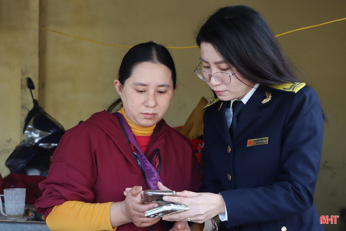 Cán bộ Thuế cơ sở 6 tỉnh Hà Tĩnh hỗ trợ tiểu thương chợ Kỳ Lâm kê khai trên ứng dụng thuế điện tử.