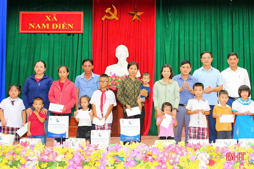 Phó Chủ tịch UBND huyện Nguyễn Bá Hà trao quà cho em nhỏ tại xã Nam Điền.