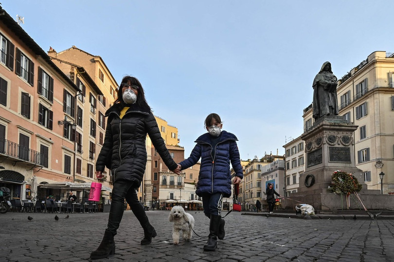 Mẹ dắt tay con gái nhỏ và chó cưng đi dạo ở quảng trường Campo Dei Fiori vắng vẻ ở trung tâm Roma hôm 10/3. Ảnh: Getty Images. Số ca tử vong mới vì Covid-19 tăng kỷ lục tại Italy, cao gấp 10 lần Trung Quốc