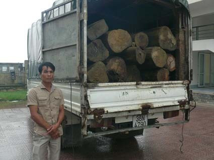 Đối tượng và số gỗ bị thu giữ.