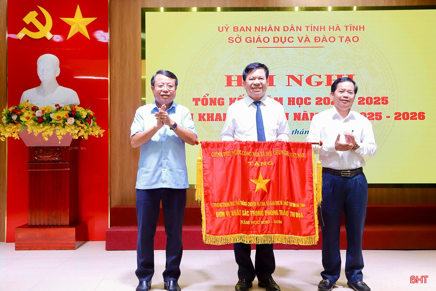 Phó Chủ tịch UBND tỉnh Dương Tất Thắng và Phó Trưởng ban Thường trực Ban Tuyên giáo và Dân vận Tỉnh ủy Bùi Nhân Sâm trao tặng Cờ thi đua của Chính phủ cho tập thể Trường THPT Chuyên Hà Tĩnh. bqbht_br_img-3185-copy.jpg