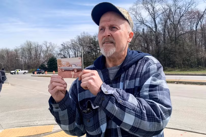 Christopher Romey cầm bức ảnh của mình bên cây cầu Francis Scott Key ở Baltimore vào những năm 1980. Ảnh: Guardian.