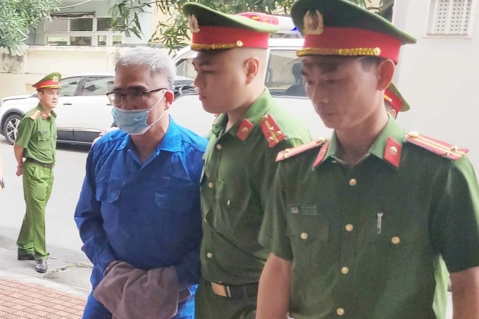 7h50, ông Ca được dẫn giải vào phiên tòa. Ông gầy hơn trước khi bị bắt, đi lại khó khăn. Ảnh: Lê Tân