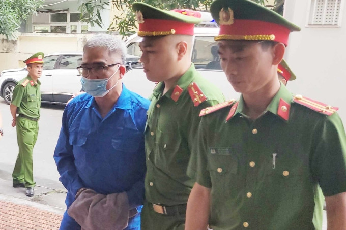 7h50, ông Ca được dẫn giải vào phiên tòa. Ông gầy hơn trước khi bị bắt, đi lại khó khăn. Ảnh: Lê Tân 7h50, ông Ca được dẫn giải vào phiên tòa. Ông gầy hơn trước khi bị bắt, đi lại khó khăn. Ảnh: Lê Tân