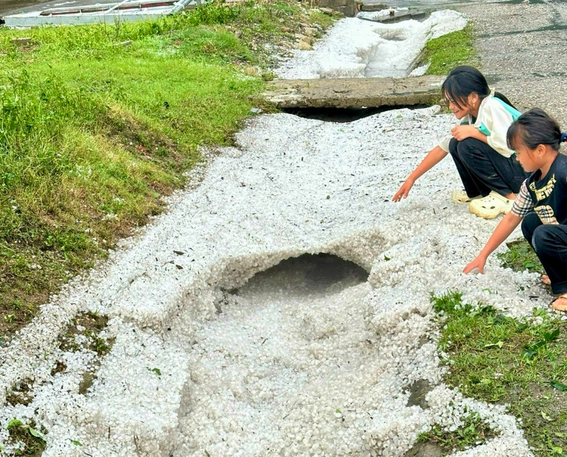 Những hạt đá đường kính 1-2 cm sau khi tiếp đất bị nước mưa cuốn dày đặc hai bên lề quốc lộ 6.