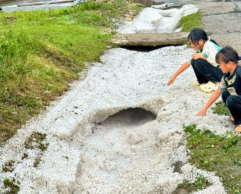 Những hạt đá đường kính 1-2 cm sau khi tiếp đất bị nước mưa cuốn dày đặc hai bên lề quốc lộ 6.