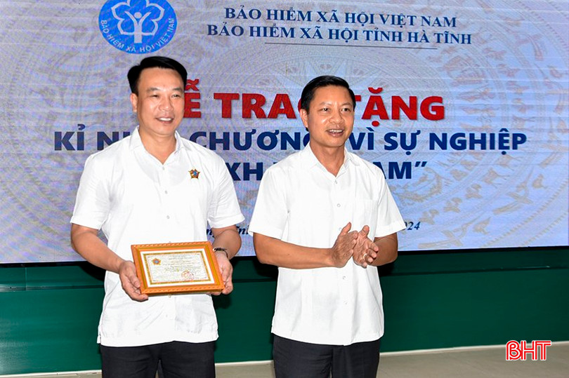 Giám đốc BHXH tỉnh Nguyễn Văn Đồng trao Kỷ niệm chương Vì sự nghiệp BHXH Việt Nam cho Chủ tịch UBND thị xã Hồng Lĩnh Nguyễn Huy Hùng. 2.jpg