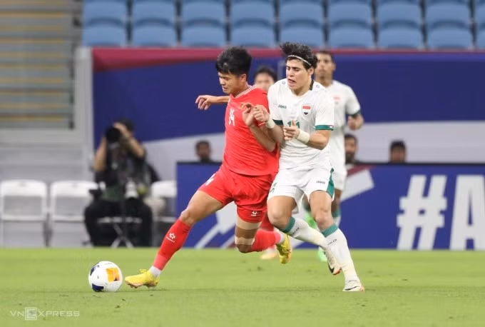 Văn Tùng (đỏ) đi bóng trong sự truy cản của Muhammed Ali bên phía Iraq. Ảnh: Đoàn Huynh