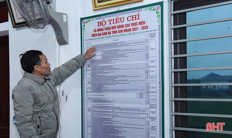 Anh Trân nghiên cứu bộ tiêu chí xã NTM nâng cao được treo tại nhà văn hoá thôn. bqbht_br_a3.jpg