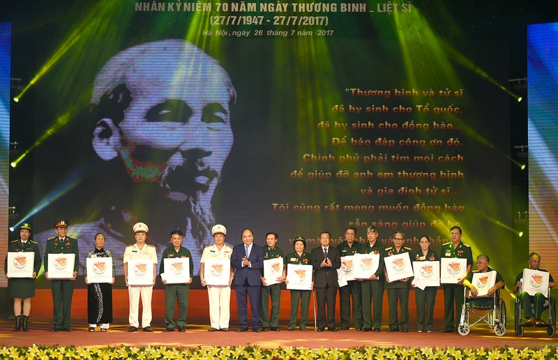 Thủ tướng Nguyễn Xuân Phúc tặng quà cho các đại biểu người có công. - Ảnh: VGP/Quang Hiếu thu tuong chung ta nguyen song xung dang voi nhung cong hien hy sinh cua dong chi dong bao