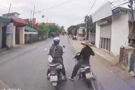 2 phụ nữ dừng xe máy giữa đường nói chuyện, ôtô không thể di chuyển