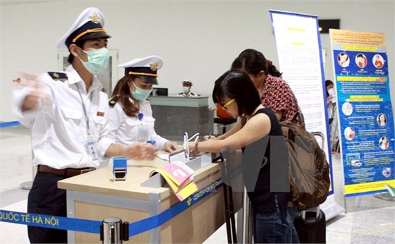 Hành khách từ Hàn Quốc nhập cảnh đến Việt Nam thực hiện kê khai y tế. (Ảnh: Dương Ngọc/TTXVN)