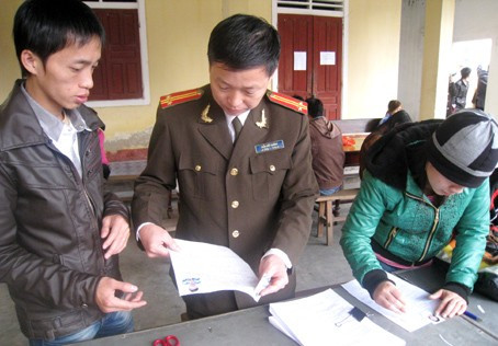 Cán bộ phòng PA61 hướng dẫn người dân viết hồ sơ làm hộ chiếu, giấy thông hành