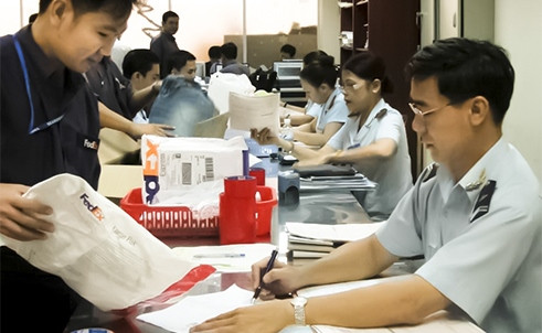 Giảm bớt chứng từ trong bộ hồ sơ hải quan sẽ tạo thuận lợi nhiều cho DN. (Trong ảnh: Hải quan chuyển phát nhanh TP.HCM làm thủ tục cho doanh nghiệp. Ảnh: T.Hòa)