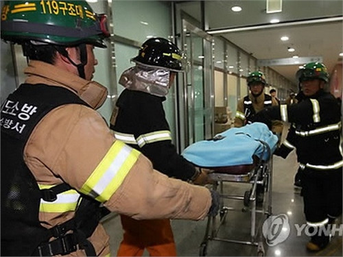 Cảnh sát phòng cháy chữa cháy vận chuyển người bị thương đến bệnh viện. (Nguồn: Yonhap)