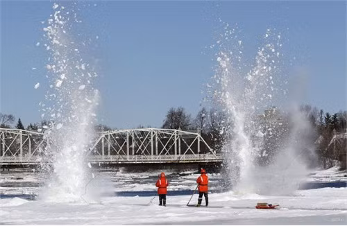Người công nhân đang đặt chất nổ để phá các tảng băng trên sông Rideau ở Ottawa, Ontario. Hằng năm, thành phố Ottawa đều tiến hàng việc phá băng dọc theo sông Rideau để giảm bớt lũ lụt có thể xảy ra vào mùa xuân